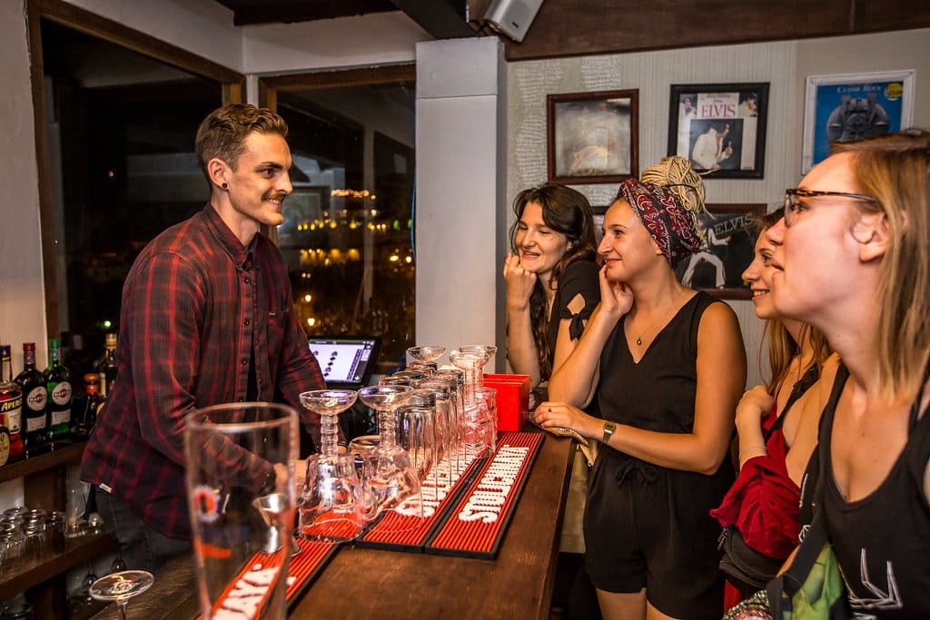 Bartender getting drink orders from women at Compadre Barbers & Rooftop Club Panama