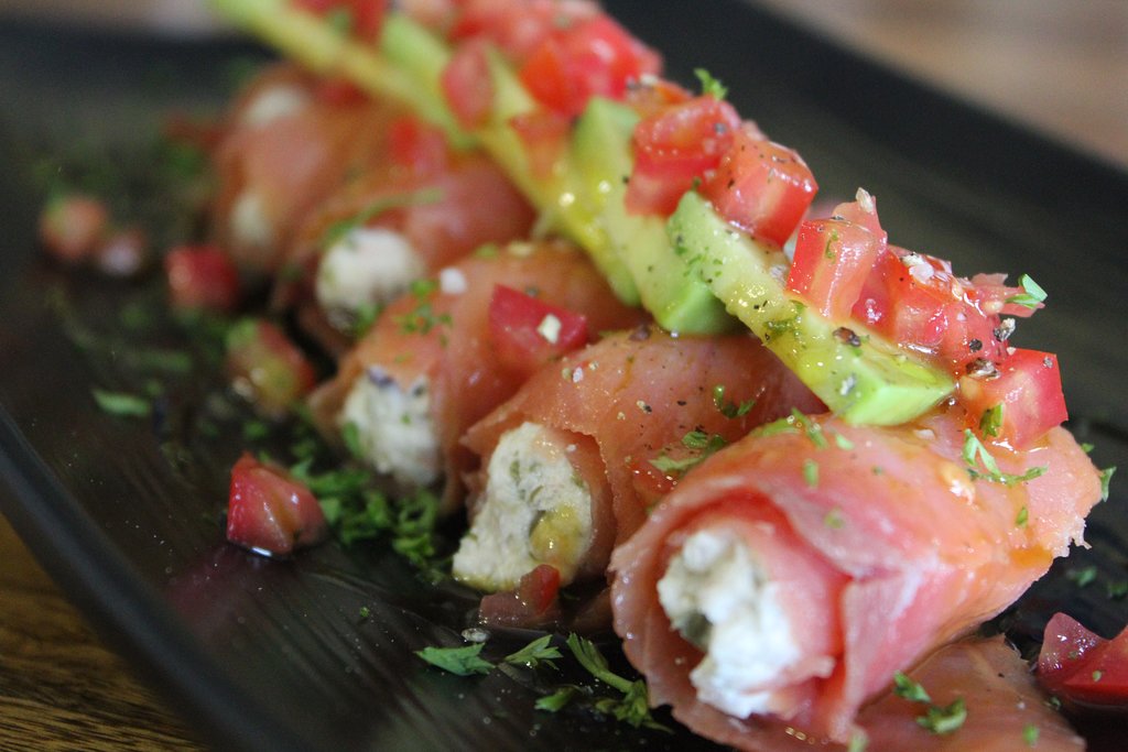 Smoked salmon rolls with avocado and tomato 