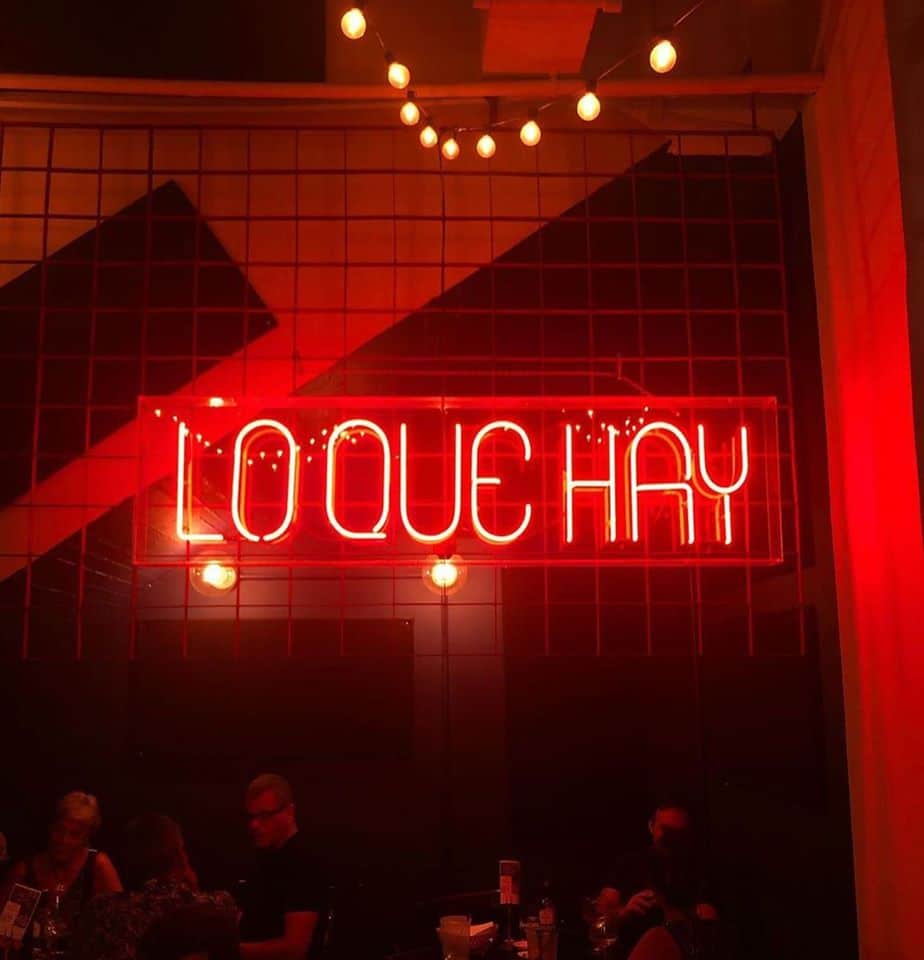 Famous Lo Que Hay neon sign on the wall 