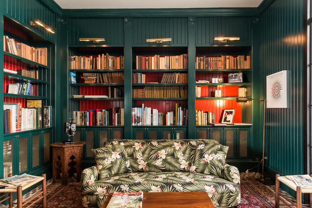 Library with books and tropical sofa in American Trade Hotel
