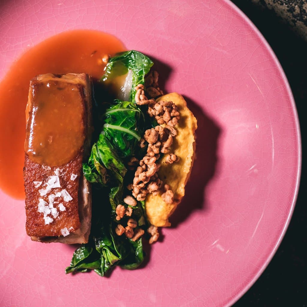 Duck “bocatto di cardinale” with a cloud of palm heart, fermented black garlic sauce and sautéed Chinese cabbage in Caliope Restaurant.