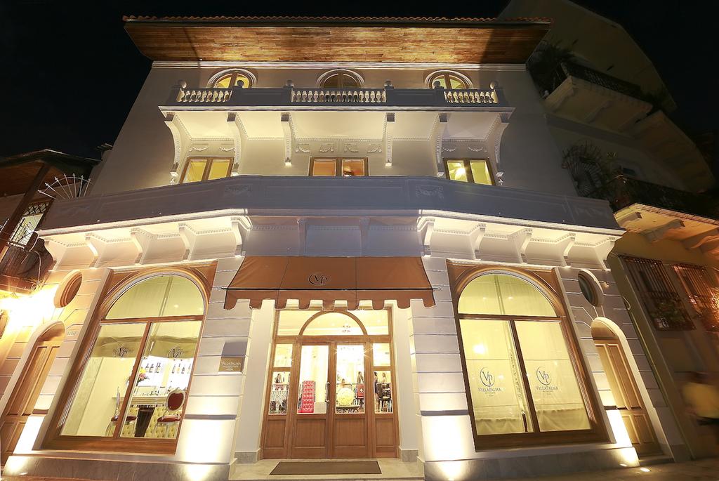 Exterior view of the Villa Palma Boutique Hotel building illuminated at night