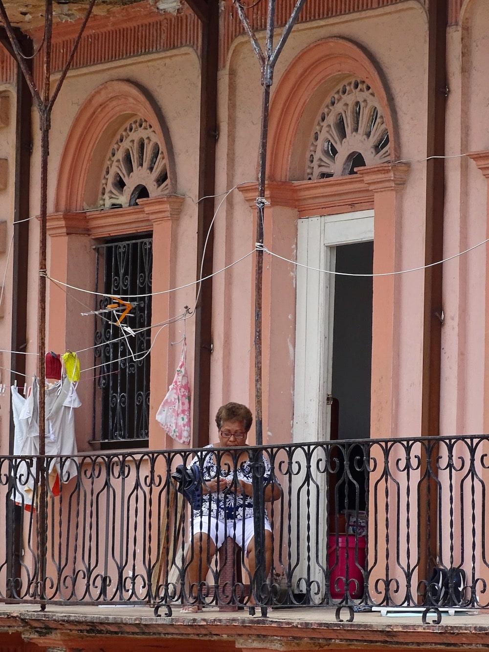 Mujer sentada en su balcón en el Casco Viejo de Panamá