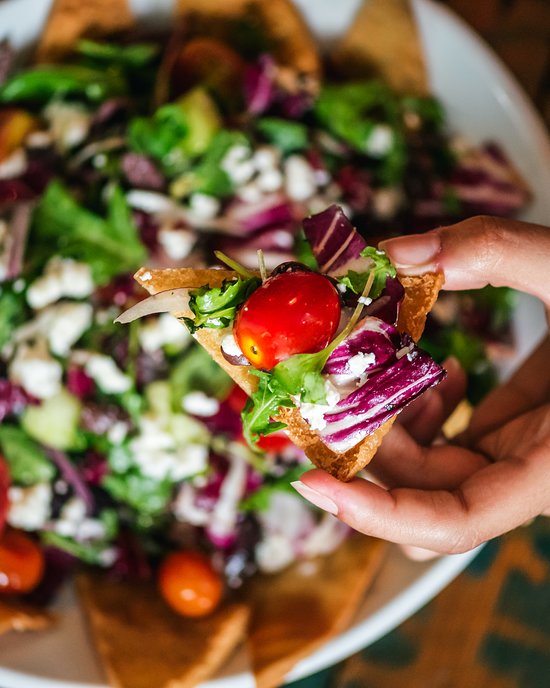 Ensalada recogida en un chip de pita