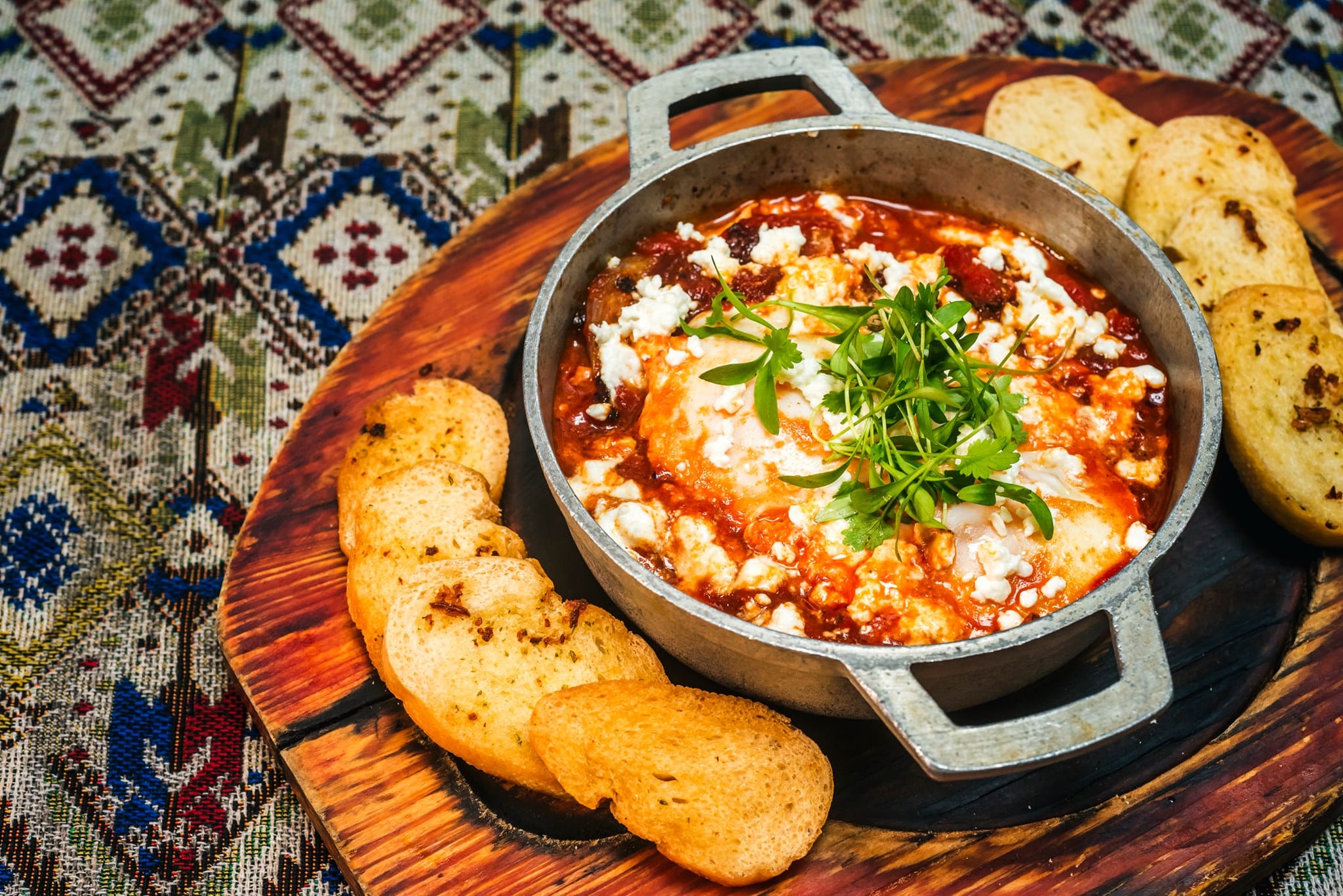 Shakshuka israelí, huevos en un recipiente de metal con pan