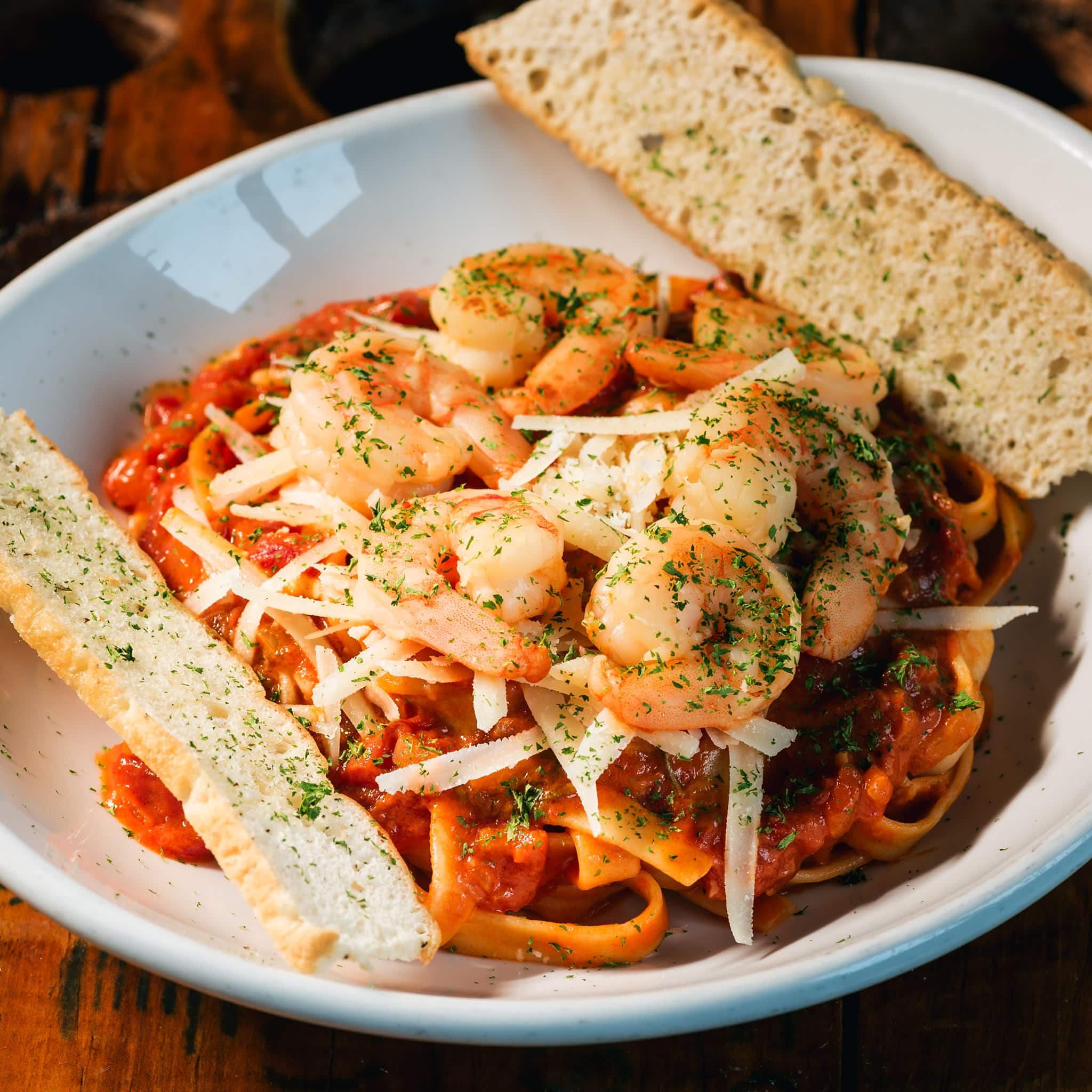 Pasta con camarones acompañada de pan en Tantalo Kitchen